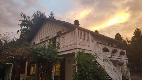 a house with a balcony and a sunset in the background at RubyJune Inn in White Salmon