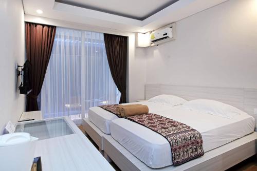 1 dormitorio con 1 cama grande y mesa de cristal en Pondok Nyaman 15 en Denpasar