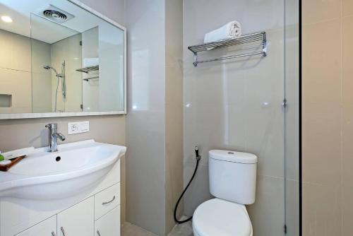 W łazience znajduje się umywalka, toaleta i lustro. w obiekcie Pondok Nyaman 15 w mieście Denpasar