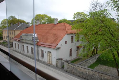 a white building with a red roof on a street at KURESSAARE TALLINN STREET APARTMENTs in Kuressaare
