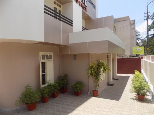 a building with potted plants in front of it at Safire Residency in Trivandrum