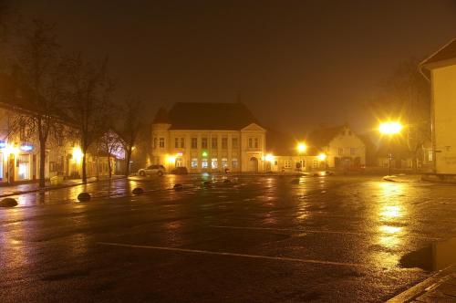 an empty parking lot at night with a building at KURESSAARE TALLINN STREET APARTMENTs in Kuressaare