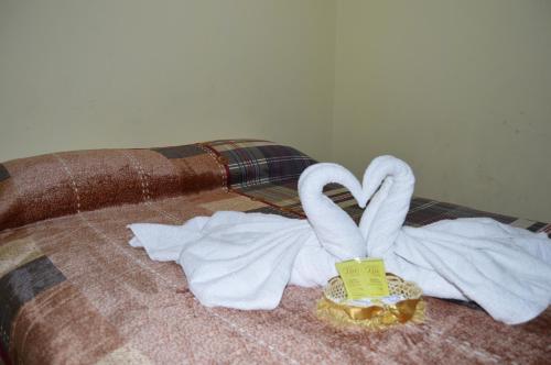 a bed with towels and a couple of swans at Balcones del Río Hotel in Latacunga