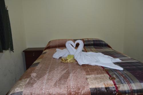 a bed with two swans made out of towels at Balcones del Río Hotel in Latacunga