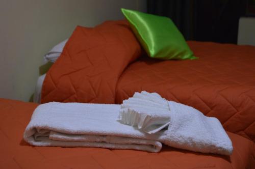 a pile of towels sitting on top of a bed at Balcones del Río Hotel in Latacunga