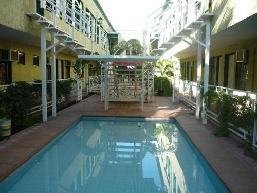 a swimming pool in front of a building at Hotel Coranda in Colima