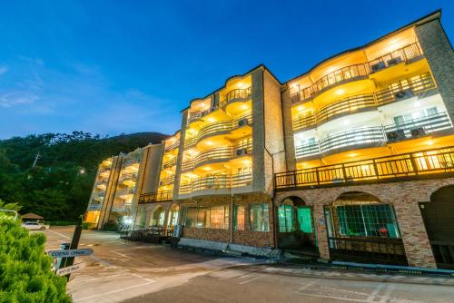 a large building with lights on in a parking lot at Home Fourest Resort Geoje in Geoje 