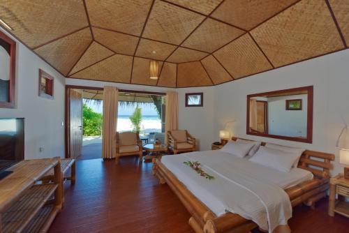 a bedroom with a large bed and a table at Thulhagiri Island Resort & Spa in North Male Atoll