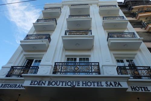 a tall white building with a sign on it at Eden Boutique Hotel & Spa in Sa Pa