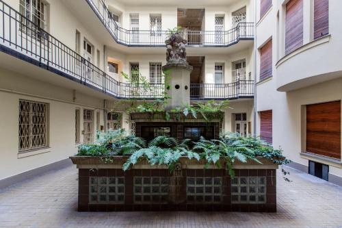 a courtyard of an apartment building with a fountain at A Golden Star Modern Luxury Apartments and Rooms Budapest in Budapest
