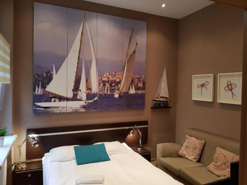 a bedroom with a bed and a large painting of sailboats at Kamienica Poznańska 7 in Bydgoszcz