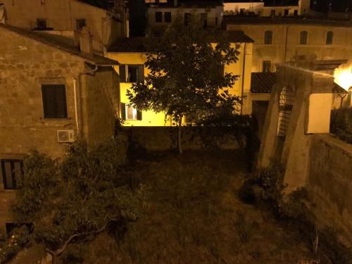 an alley at night with a tree and buildings at La Terrazza in Tuscania