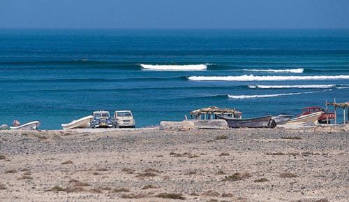 two boats on a beach near the water at Al Reem Chalet in Al Ashkharah