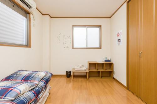 a bedroom with a bed and a window and a table at Awaza House 2 in Osaka