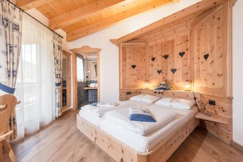 een groot bed in een kamer met een houten muur bij Agritur La Val in Vigolo Vattaro