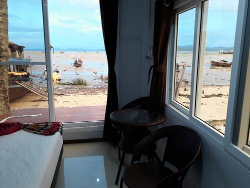 a room with a window with a view of the beach at Seaside home in Koh Mook