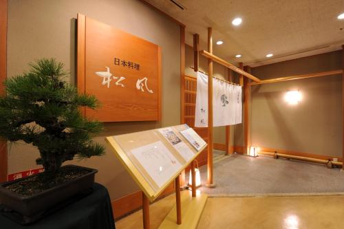 a room with a potted tree and a sign at Nishitetsu Grand Hotel in Fukuoka