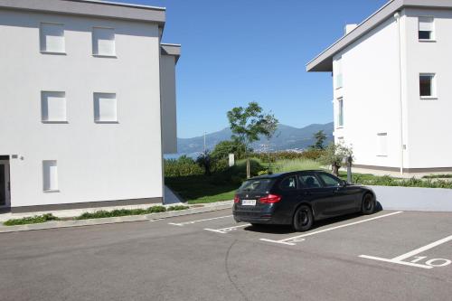 a black car parked in a parking lot next to a building at Studio apartment Miramare breakfast and parking in Rijeka
