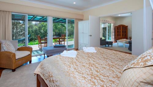 a bedroom with a large bed and a balcony at Crystal Creek Meadows in Kangaroo Valley