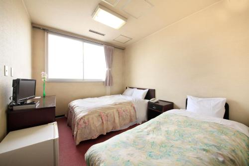 A bed or beds in a room at 吸う温泉 湯治の宿 竜王ラドン温泉 湯ーとぴあ