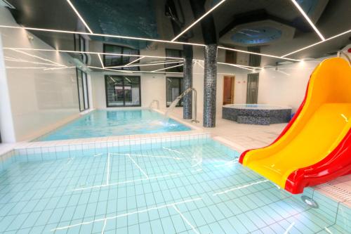 una piscina con un tobogán en un edificio en 5 Zmysłów akademia wypoczynku Pokoje, en Grzybowo