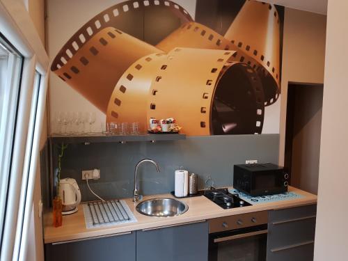 a small kitchen with a sink and a microwave at Kamienica Poznańska 7 in Bydgoszcz