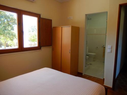Quinta Laranjal da Arrabida في بالميلا: غرفة نوم مع سرير ودش زجاجي