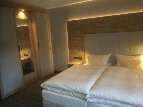 a large white bed in a hotel room at Landgasthof Kleiner in Sundern