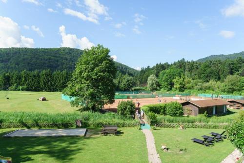 a park with picnic tables and benches in the grass at Sportpark Warmbad-Villach in Villach