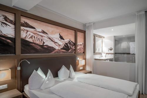 - une chambre avec un lit blanc orné d'une peinture murale dans l'établissement Wellness & Relax Hotel Milderer Hof, à Neustift im Stubaital