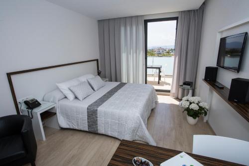 ApartHotel Playa Oliva في أوليفا: غرفه فندقيه بسرير وشرفه