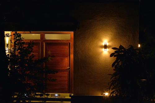 a door to a building at night with lights at Kings Village Sigiriya in Sigiriya