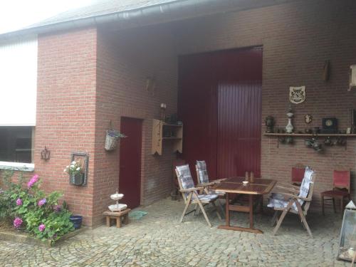 a patio with a table and chairs and a brick building at Voyago room relax ride in Cadier en Keer