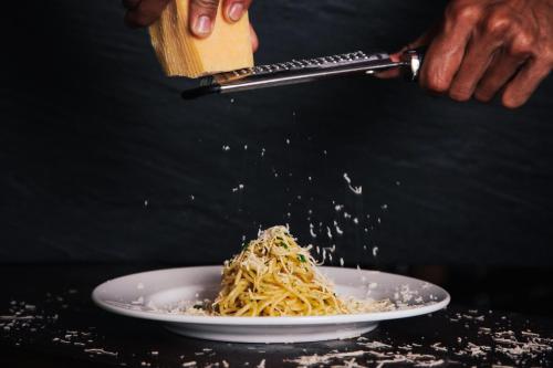 a person is sprinkling noodles on a plate at Salana Boutique Hotel in Vientiane