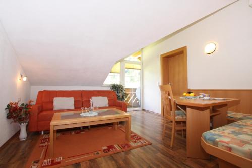 a living room with a red couch and a table at Apart Rustica in Kaunertal