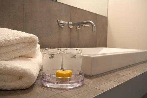ein Badezimmer mit Handtüchern, einem Waschbecken und einer Kerze in der Unterkunft Biedermann's Suiten in Grän