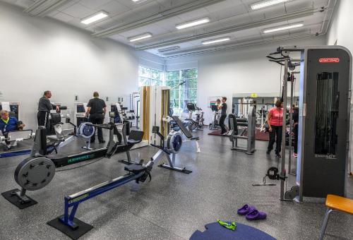 a gym with treadmills and people in a room at Kiipula Guest House in Turenki