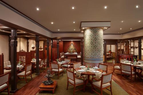 a restaurant with tables and chairs and a column at Cinnamon Lakeside in Colombo