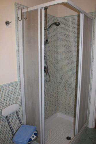 a shower with a glass door and a chair in a bathroom at AFFITTACAMERE La Tartaruga in Civitanova Marche