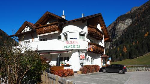 a building with a car parked in front of it at Apart Rustica in Kaunertal