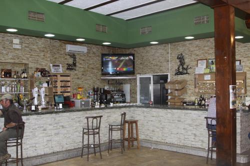 a man sitting at a bar in a restaurant at Hostal La Zarza in Brazatortas