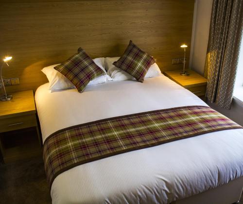 ein Schlafzimmer mit einem großen Bett mit Kissen darauf in der Unterkunft King Alfred Hotel in Barrow in Furness