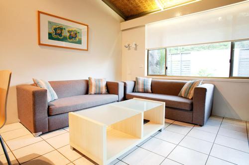 a living room with two couches and a coffee table at Nautilus Beachfront Villas & Spa in Coffs Harbour