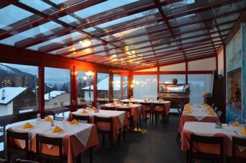 a dining room with tables and a piano at Pensione Cari in Molare