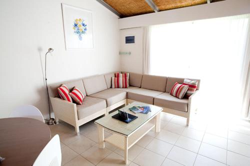 a living room with a couch and a table at Nautilus Beachfront Villas & Spa in Coffs Harbour