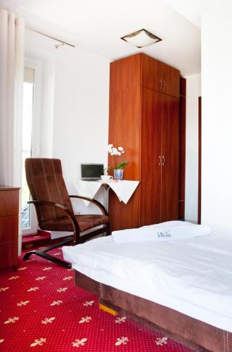 a bedroom with a bed and a chair and a desk at Villa Park in Bukowina Tatrzańska