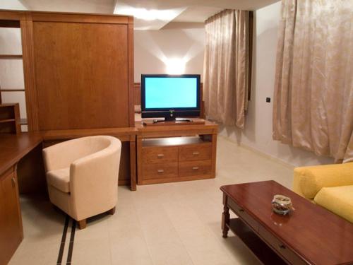 a living room with a television on a wooden desk at Hotel Gio in Arad