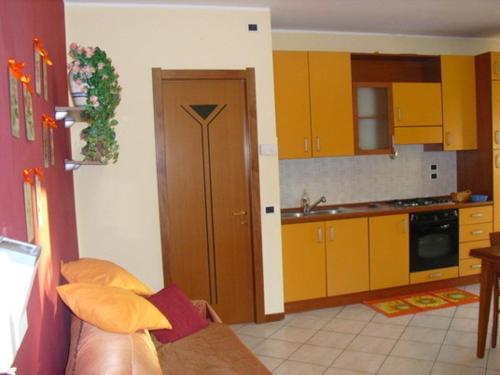 a kitchen with yellow cabinets and a brown door at Case Vacanze Rocca in Bastia Umbra