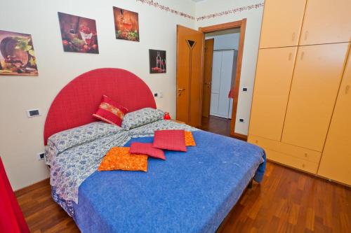 a bedroom with a blue bed with a red headboard at Case Vacanze Rocca in Bastia Umbra