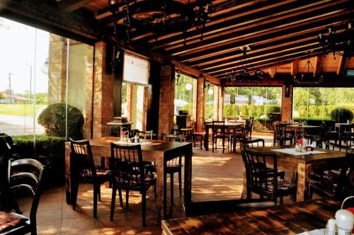 a restaurant with tables and chairs in a building at Kantár Fogadó és Étterem in Vitnyéd